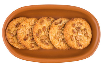 Peanut cookies in a brown plate. Isolated on white background.