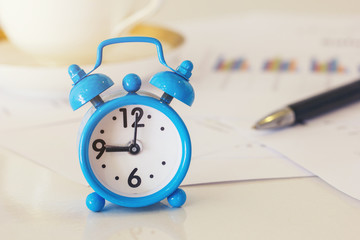 Retro Clock on desk office with business chart and pen