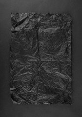 Sheet of black crumpled paper on black