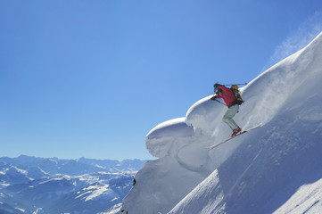 Freeskier springt mutig in einen steilen Hang