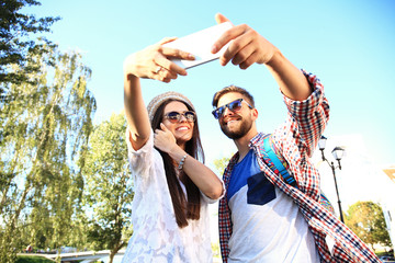 Happy couple of tourists taking selfie in city