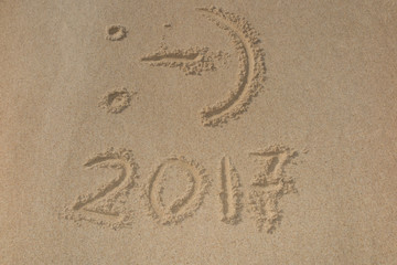Digits 2017 on the sand seashore - concept of new year