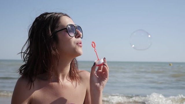 Caucasian woman on the sea beach playing with air water transparent balls slow motion 1920X1080 FullHD footage - Soap bubbles blowing and enjoying ocean climate by female slow-mo 1080p HD video 