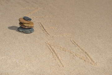 Fototapeta na wymiar Zen stone in the sand written . Background
