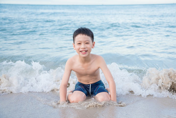 Young asian boy playing on the beach © gamelover