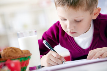 Portrait of little boy writing a letter