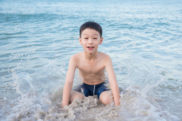Fototapeta premium Young asian boy playing on the beach