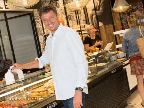 Cheerful man buying some cakes in a pastry shop