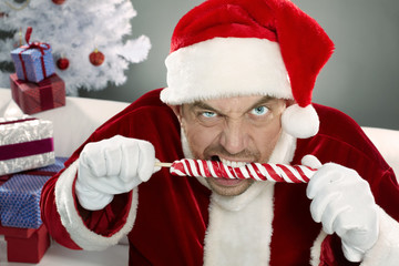 Portrait of crazy Santa gnawing lollipop 