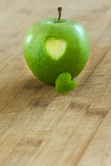Manzana en mesa de madera con un corazon (salud y concepto de dieta) 
