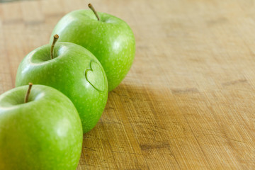 Manzana en mesa de madera con un corazon (concepto de dieta y salud) 