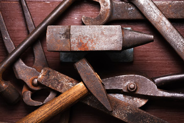 Old rusty rugged anvil and other blacksmith tools. - Powered by Adobe