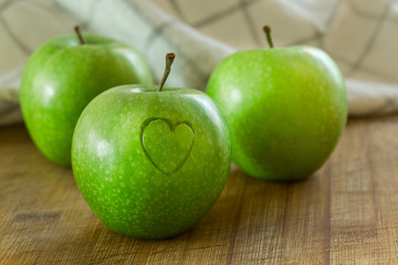 Manzana en mesa de madera con un corazon (salud y concepto de dieta) 

