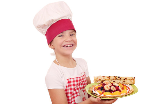 happy little girl cook with sweet crepes