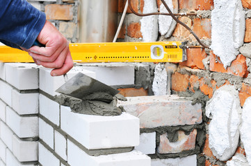 Bricklayer Using a Spirit Level to Check New White Brick Wall Outdoor. Bricklaying Basics Masonry Techniques. chimney installation