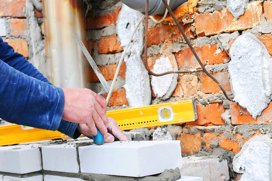 Bricklayer Using A Spirit Level To Check New White Brick Wall Outdoor. Bricklaying Basics Masonry Techniques. Chimney Installation