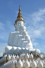 Five sitting Buddhas statue on blue sky.