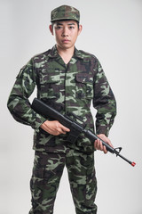 Asian soldier in green camouflage uniform with long gun - 122479830