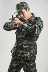 Asian soldier in green camouflage uniform with long gun - Soft Focus