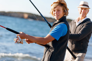 Senior man fishing with his grandson