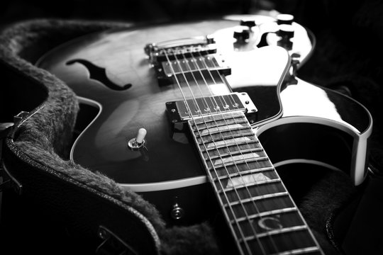 Acoustic guitar close up in dark background.B/W image.