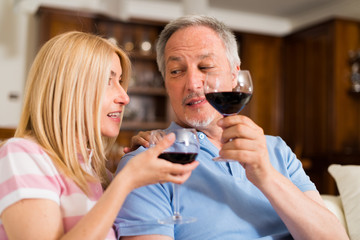 Mature couple drinking a glass of red wine