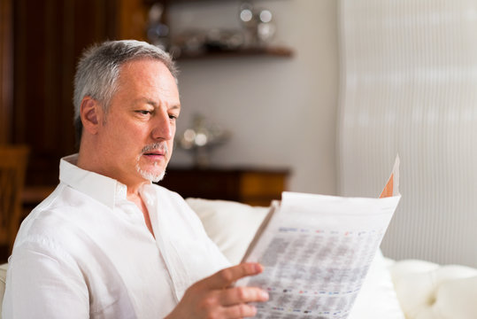 Mature Man Reading A Newspaper