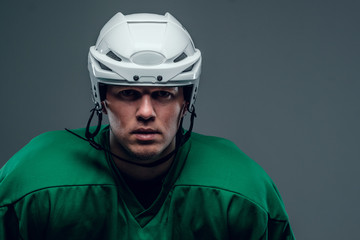 Naklejka premium Portrait of hockey player on grey background.