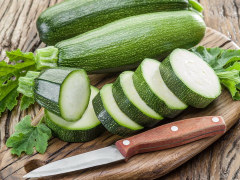 Zucchini with slices on a wooden table.