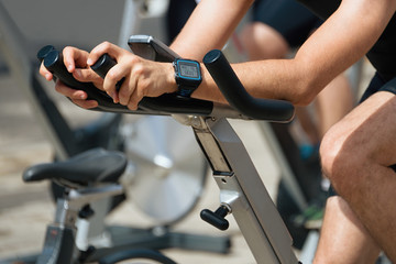 Active people working out on exercise stationary bicycle