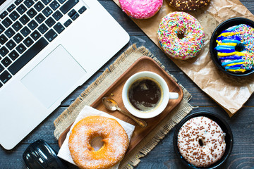 Woking Desk Table with Colorful Donuts breakfast composition