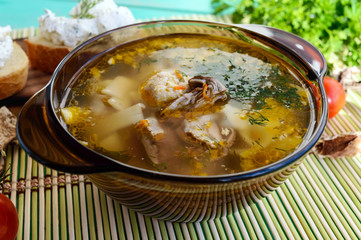 Flavored soup of dried porcini mushrooms in a glass tureen. Organic food.