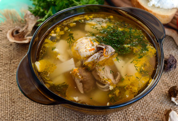 Flavored soup of dried porcini mushrooms in a glass tureen. Organic food.