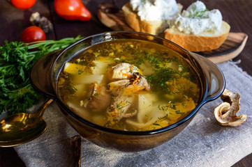 Flavored soup of dried porcini mushrooms in a glass tureen. Organic food.