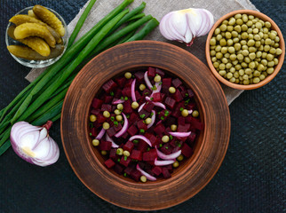 Obraz na płótnie Canvas Vitamin salad of beets, green peas, blue onion in a clay bowl. Ingredients for cooking. The top view
