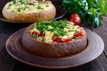 Original appetizer - stuffed rye and wheat bread, baked. Dish in rustic style