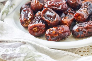 Dried dates fruit in white plate. Copy space