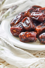 Dried dates fruit in white plate. Copy space