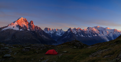 Red tent in the mountains near Chamonix, France, during a colorful sunset.