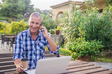 Fototapeta premium Man with laptop and coffee at summer park on bright day