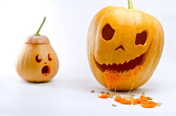 Fototapeta premium Little pumpkin scared looks at a great evil pumpkin