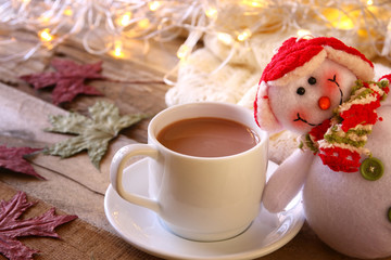 Obraz na płótnie Canvas White cup with chocolate, snowman and christmas lights