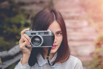 Beautiful young woman portrait wit old camera with sunrise.