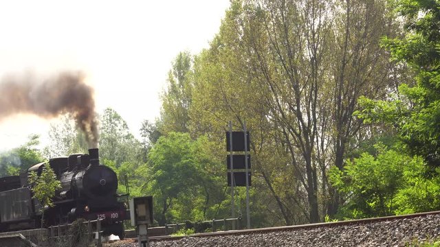 Old steam train and antique carriages runs in the countryside on the railway line Novara-Varallo Sesia, Piedmont, Italy