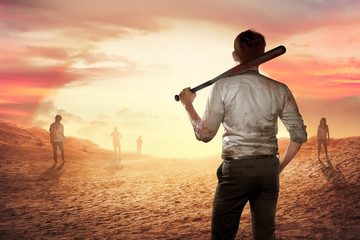 A person man holding a bloody bat at sunset