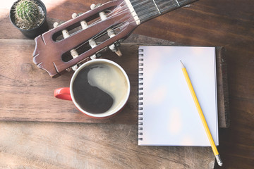Close up Acoustic guitars and coffee and cactus with a notebook
