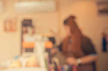 blur image of woman in restaurant or coffee shop with bokeh for background usage.(vintage tone)