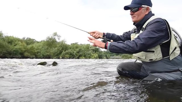 Fly-fisherman fishing in river