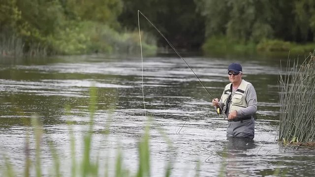 Fly-fisherman fishing in river