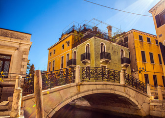 VENICE, ITALY - AUGUST 21, 2016: View on the cityscape and lovely bridge on the canal of Venice on August 21, 2016 in Venice, Italy.